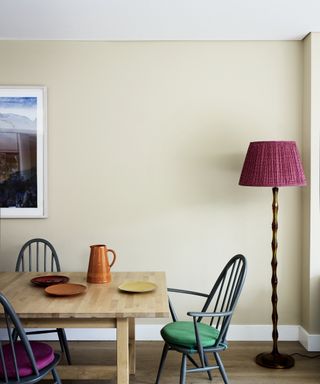 Dining room with wooden dining table and dining armchairs, floor lamp with pink lampshade