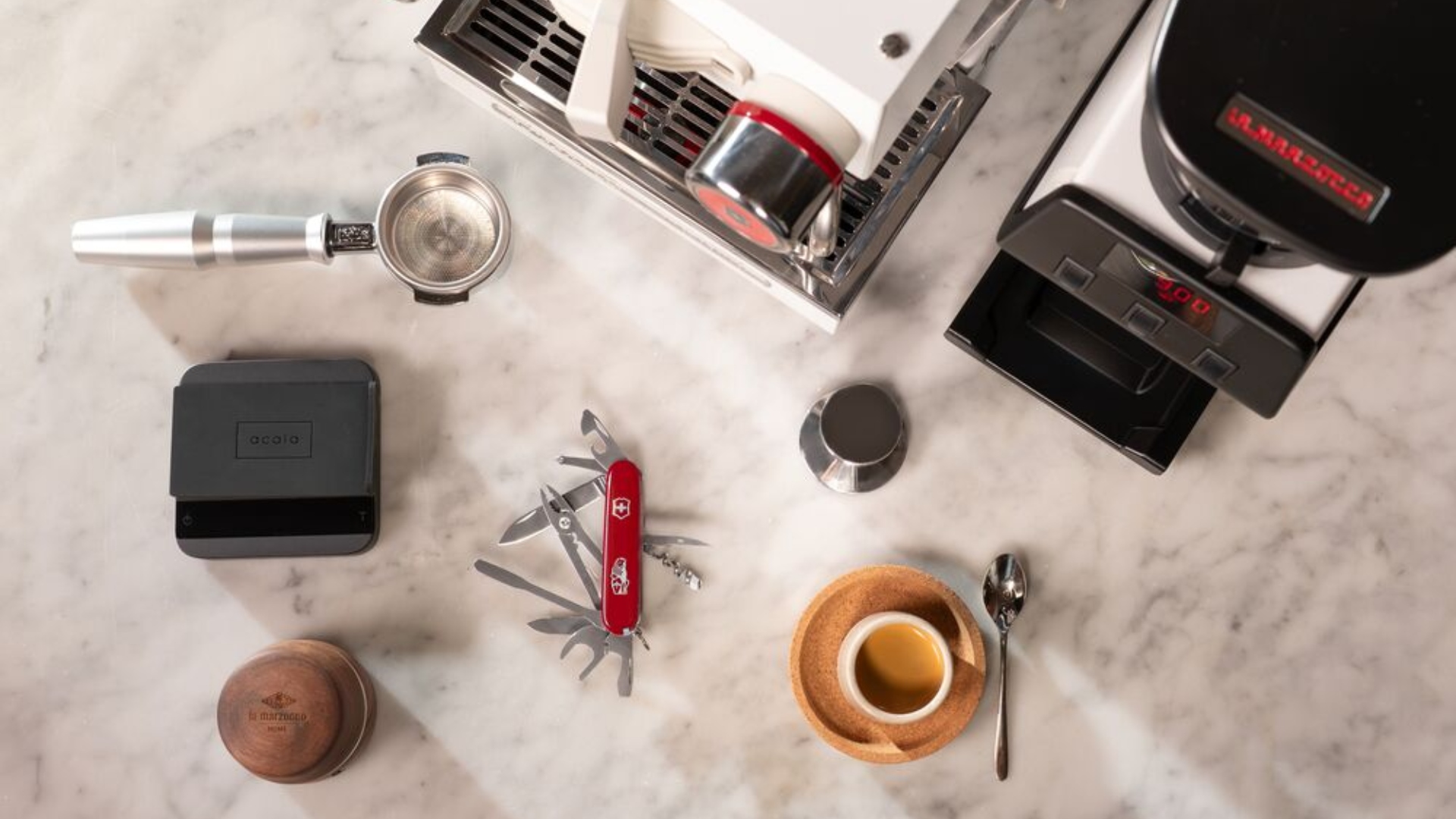 The Victorinox and La Marzocco Barista Tool laid out with other espresso gear