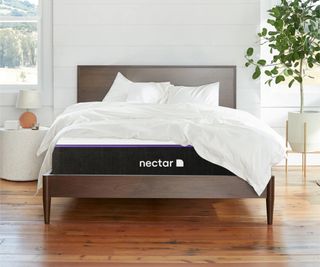 Nectar Premier Hybrid Mattress on a bed frame on a wooden floor against a white wall.