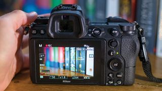 Rear LCD of Nikon Z6 II showing live view image of book shelf, while using focus peaking in video mode