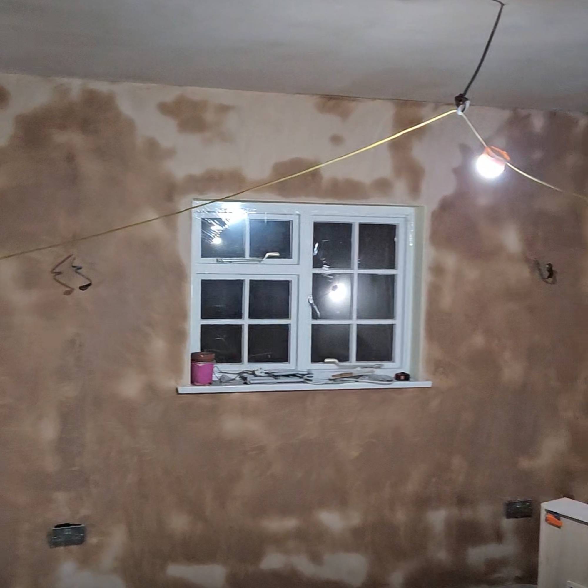 white wooden windows in freshly plastered room