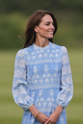 Kate Middleton looks to the side in a blue dress at polo