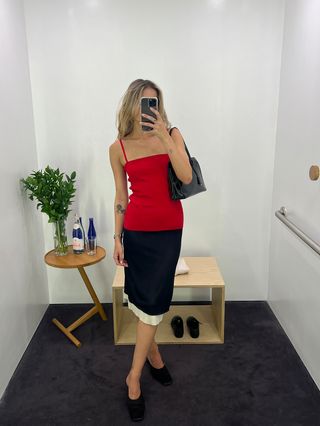 Eliza Huber wears a red tank top with a black and cream pencil skirt at COS.