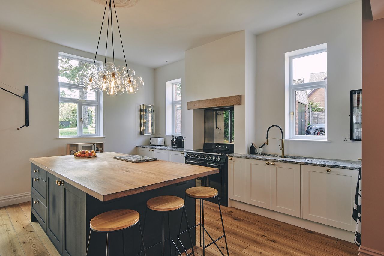 grey and blue kitchen with wood worktop and stove cooker