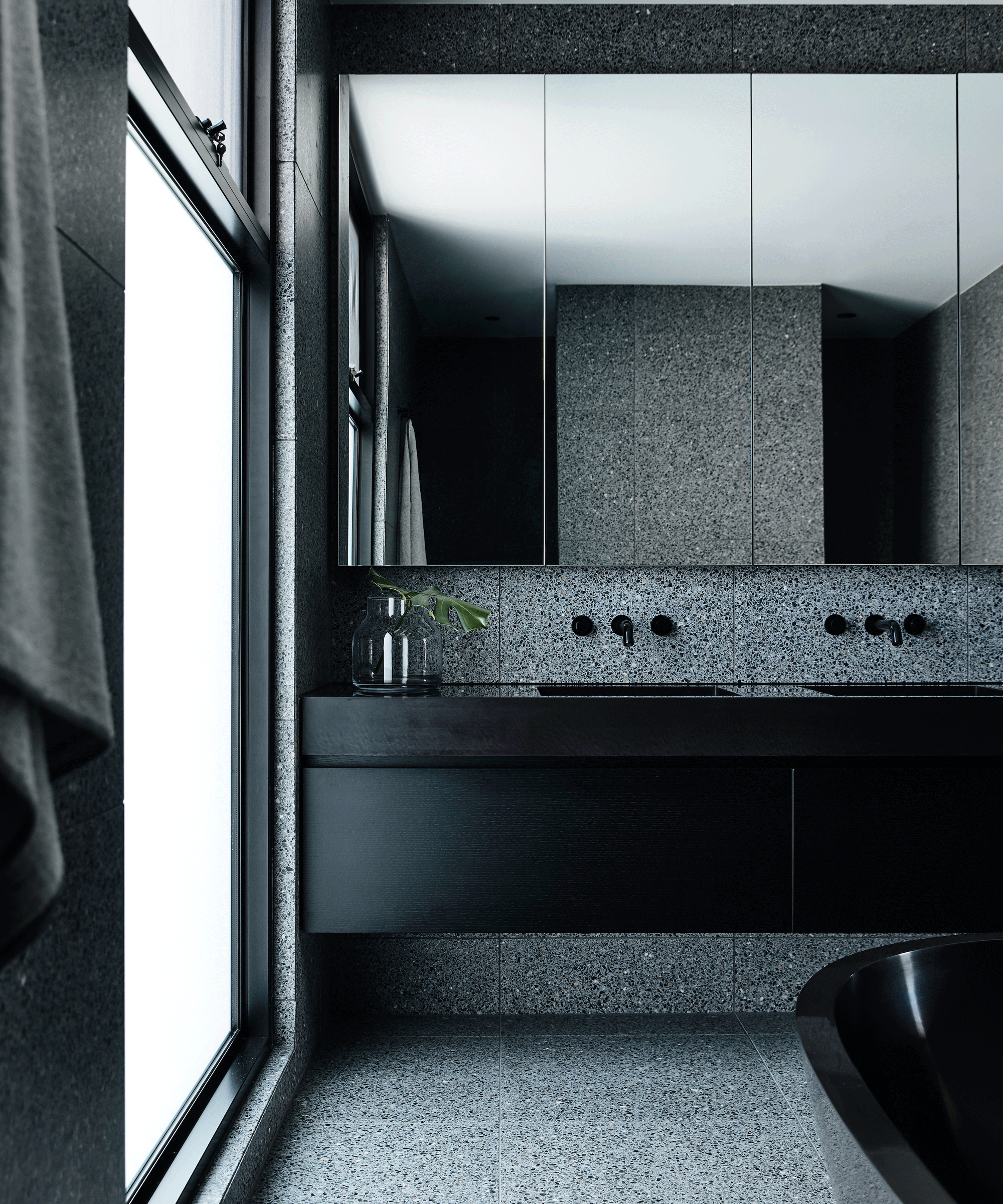 Grey terrazzo bathroom with large mirrors