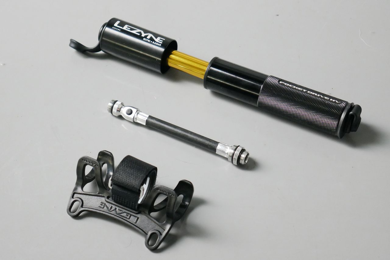Best bike mini pumps group test 2026 - Lezyne Pocket Drive sat next to its flexible hose and bottle cage mount