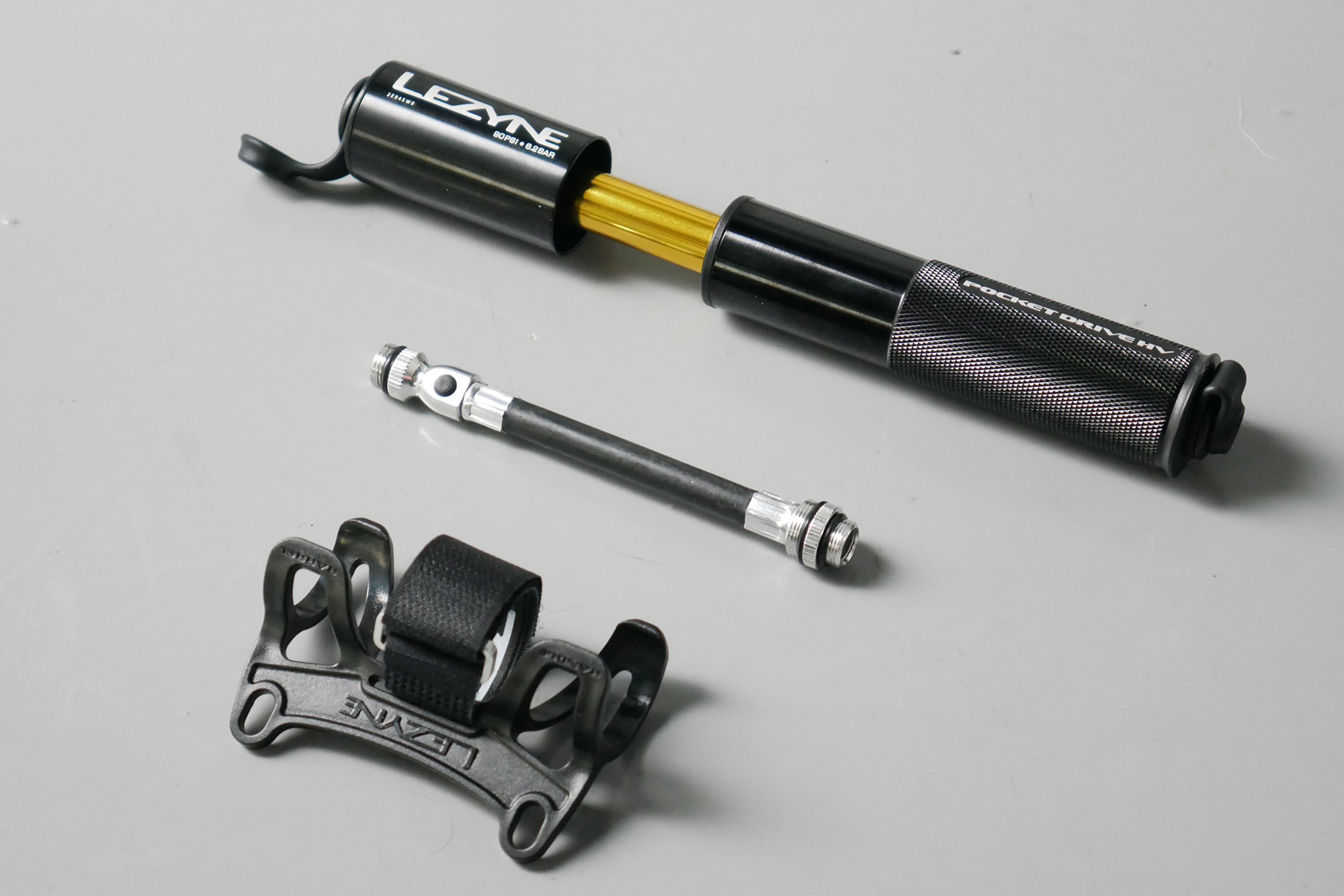 Best bike mini pumps group test 2026 - Lezyne Pocket Drive sat next to its flexible hose and bottle cage mount