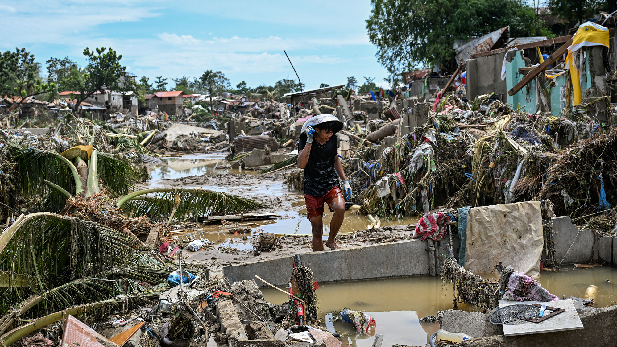 A resident walks through devastated streets in the aftermath of Typhoon Kalmaegi in Talisay, Philippines