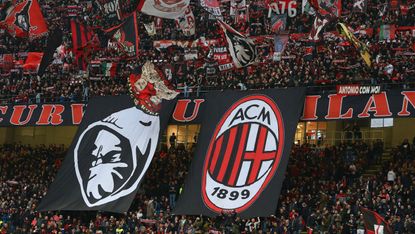 AC Milan supporters wave flags during a Serie A match at the San Siro 