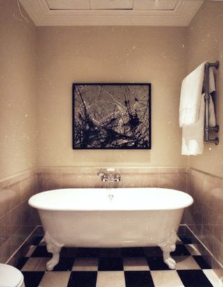 bathroom with a bathtub and black and white tiles