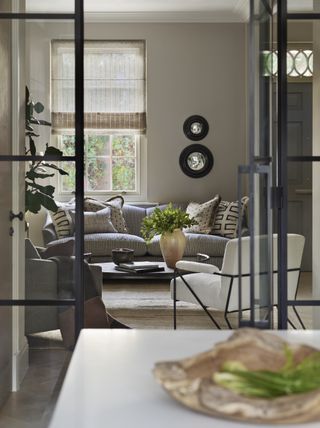 neutral living room with grey sofa taupe walls stripe linen blind crittel doors