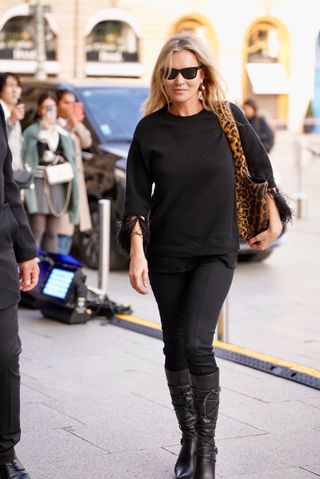 Kate Moss vor dem Ritz Paris ganz in Schwarz mit einer Saint Laurent Bea-Tasche mit Leopardenmuster.