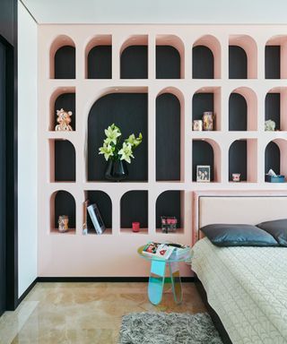 Arched pink shelving ideas in guest room by Covet House
