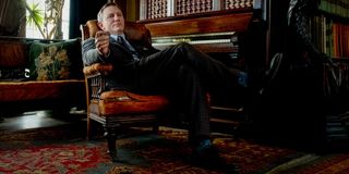 Daniel Craig sits back with a bemused smile in the library in Knives Out.