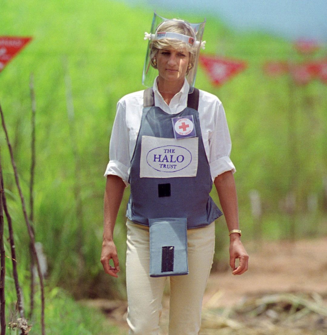 Princess Diana wearing protective gear walking through a mine field in Angola
