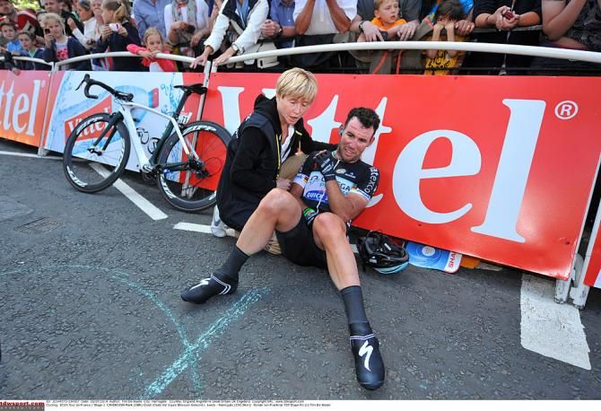 Mark Cavendish holds his injured shoulder