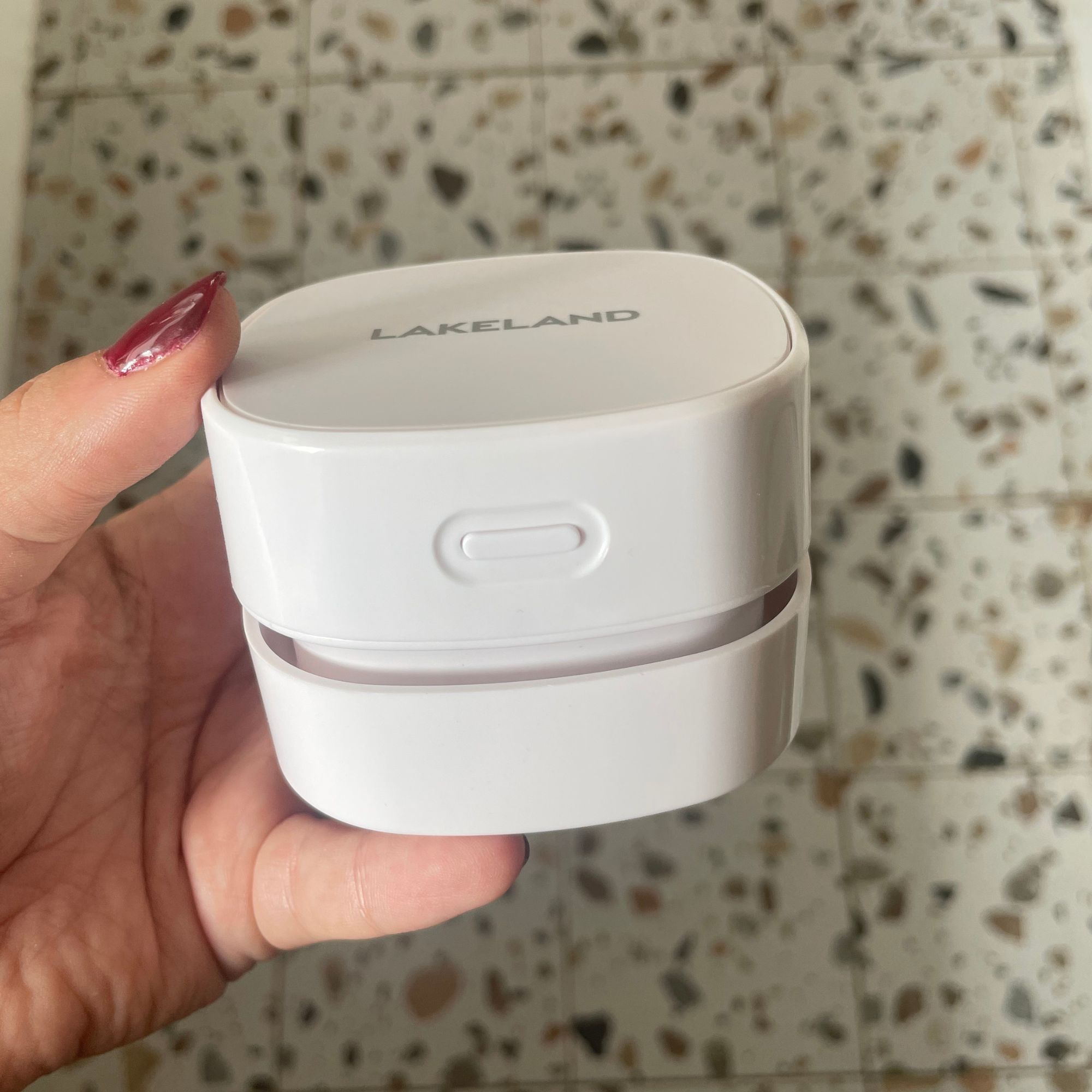 Hand holding the Lakeland mini countertop vacuum