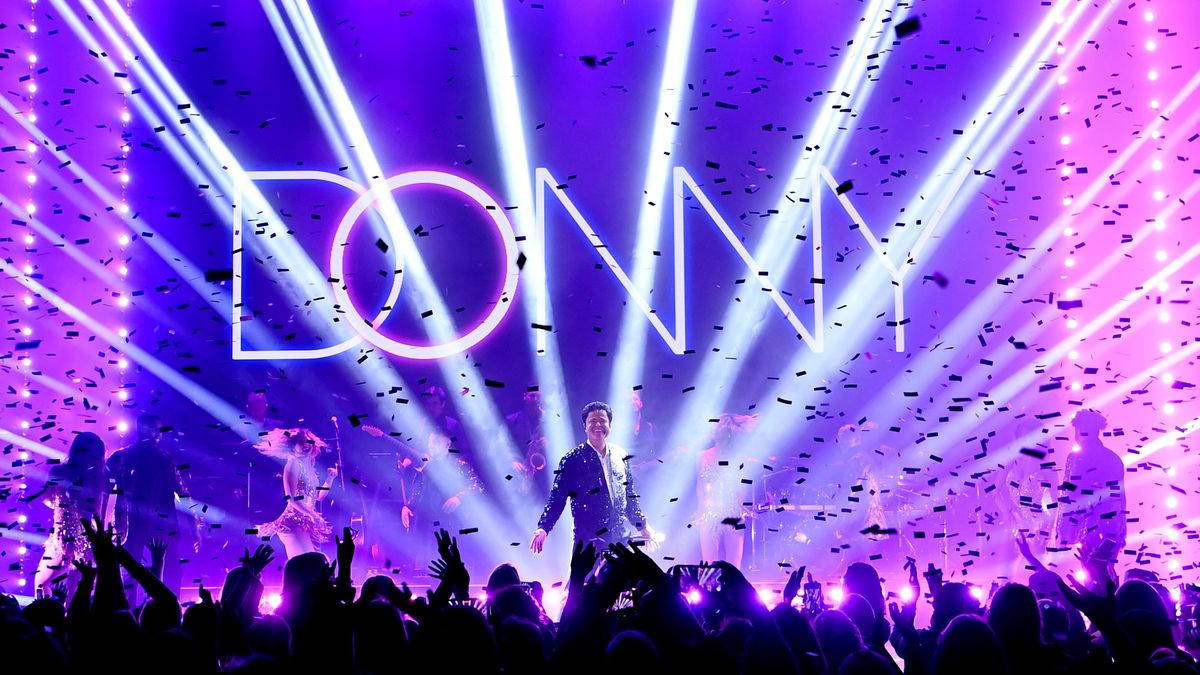 Donny Osmond is illuminated in bright purple and blue lasers and lights at his Las Vegas residency.