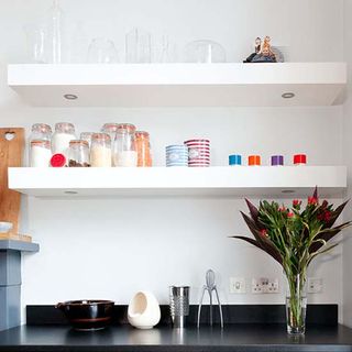 kitchen with open shelves and white wall