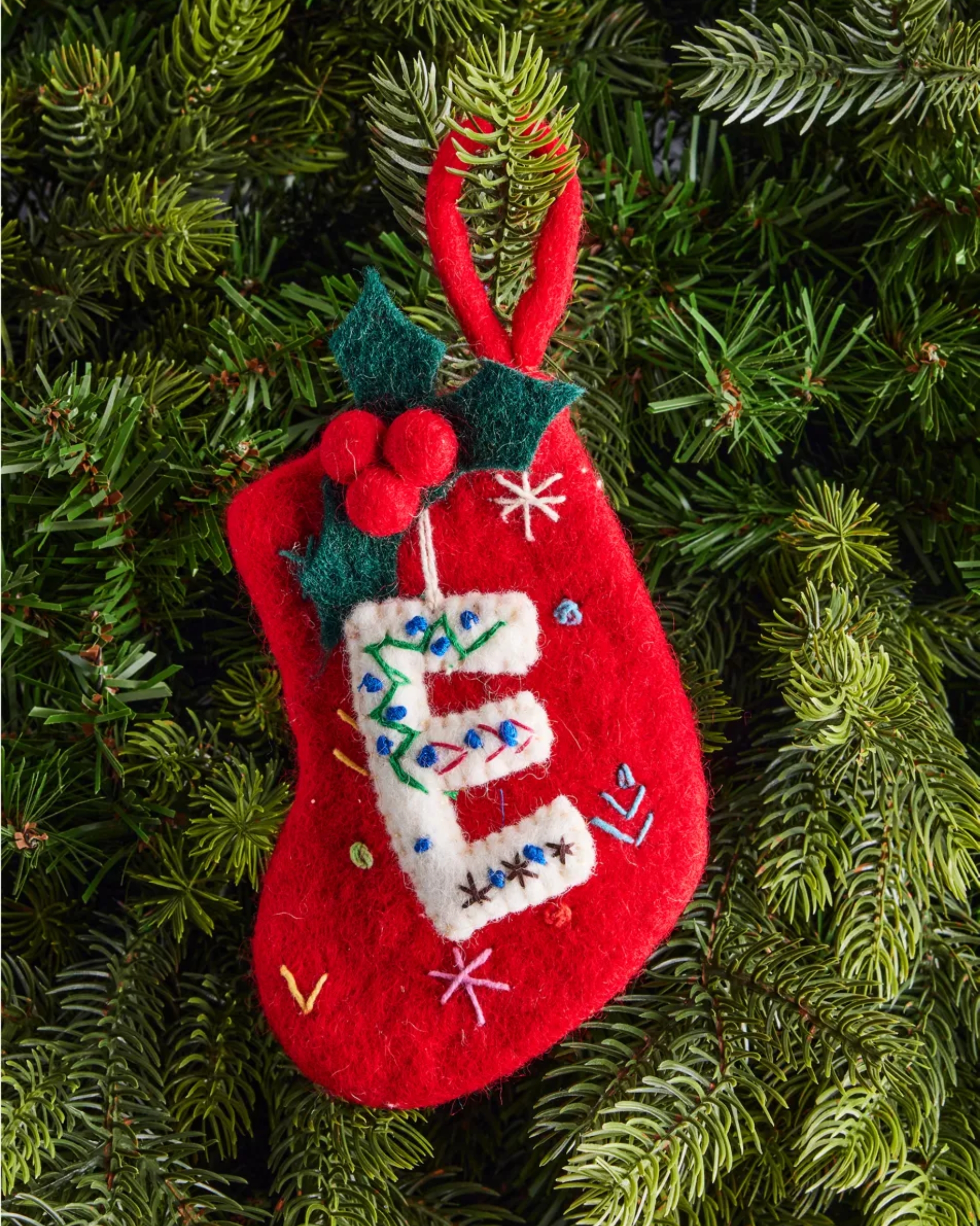 Image of a mini red stocking hanging on a Christmas tree.