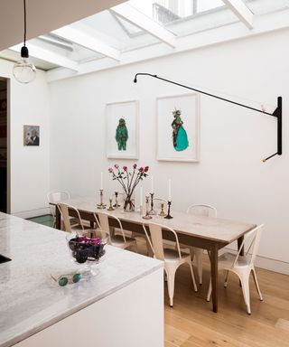 narrow dining room with white interior and wall hung lighting on pivots