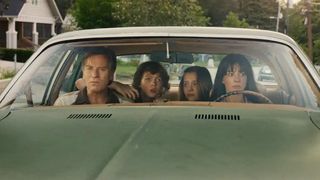 A family of four sitting in a car in The End of Oak Street