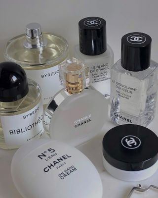 A selection of perfumes and beauty products on a white table