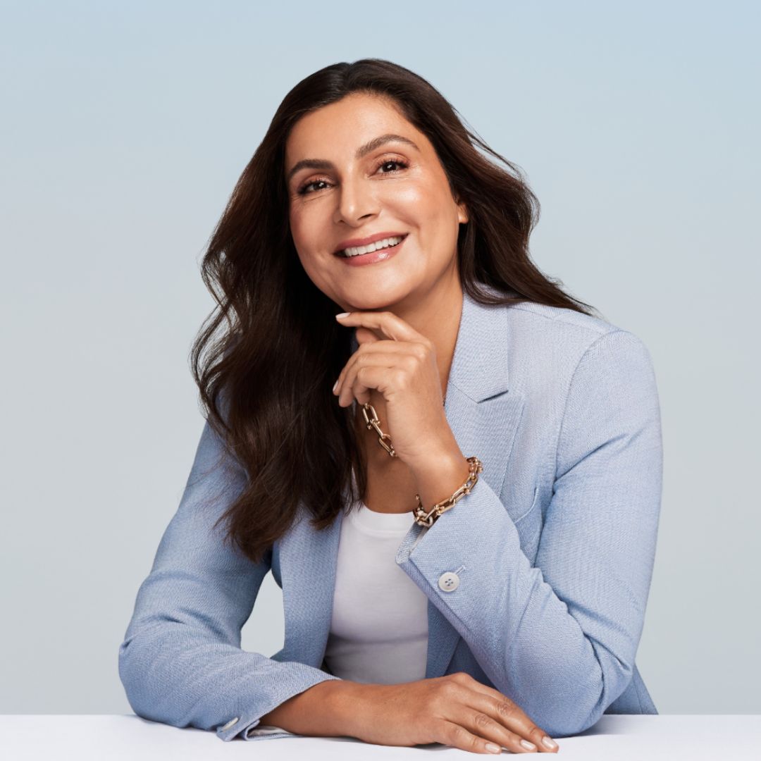 Dr. Lamees Hamdan headshot. She is wearing a blue blazer and white top in front of pal blue background