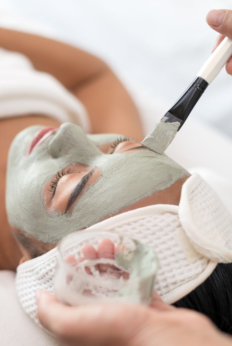 A woman having a facial mask applied