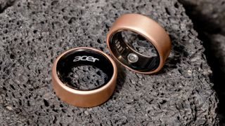 Close-up of two Acer FreeSense smart rings sitting on a moon-like surface both in rose gold
