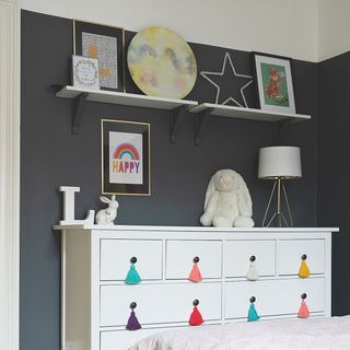 Navy bedroom wall with white drawers