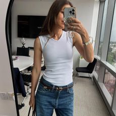 Woman in white tank top and jeans