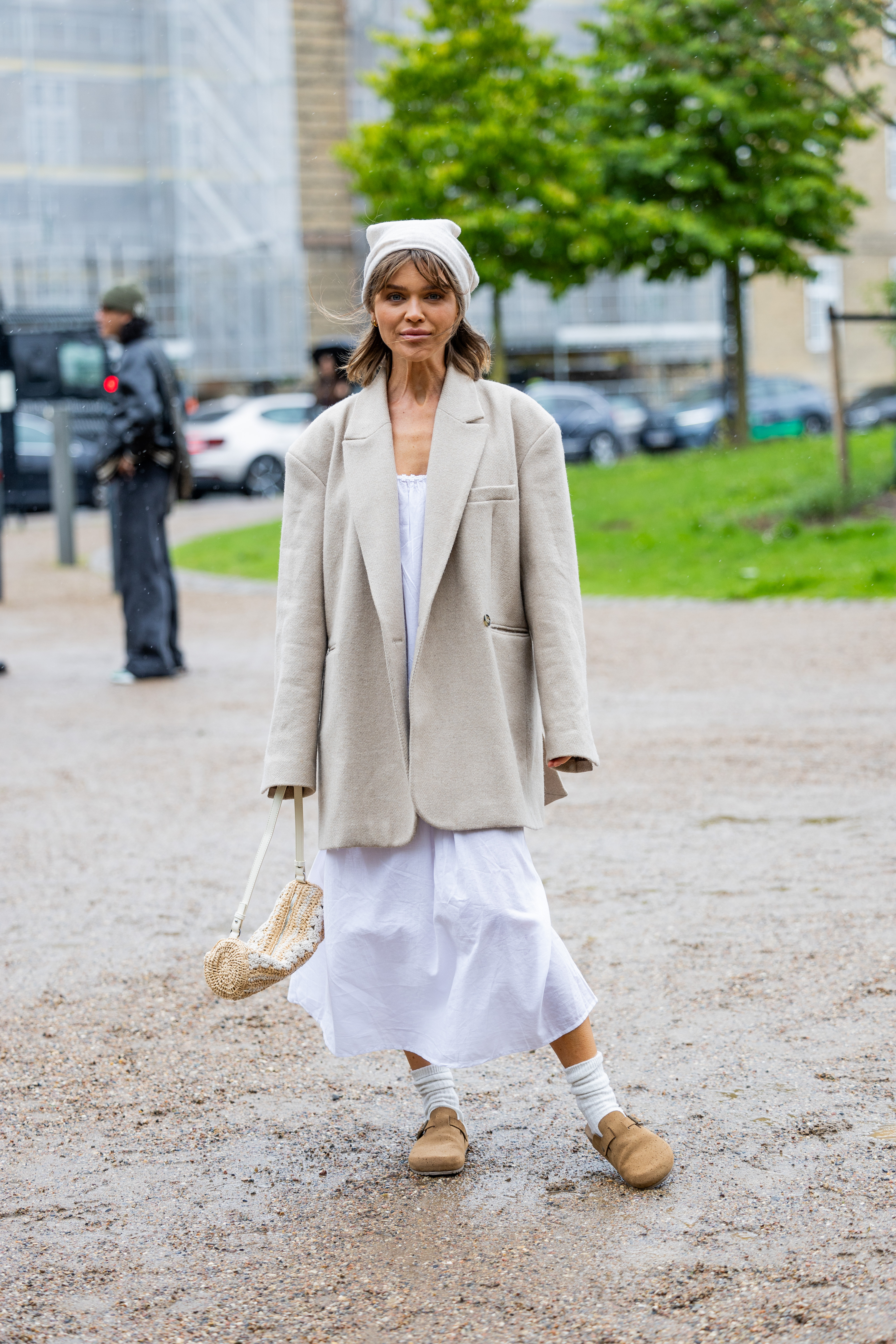 Woman wearing a summer dress, blazer, and Birkenstock clogs