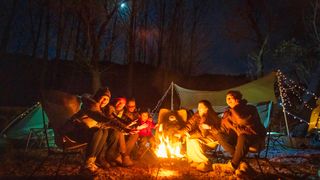 best campfire songs: family around campfire