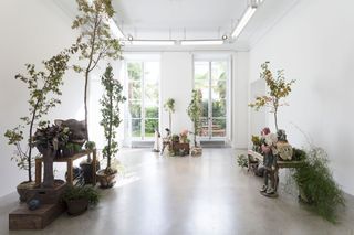 Large bright room with sculptures and foliage