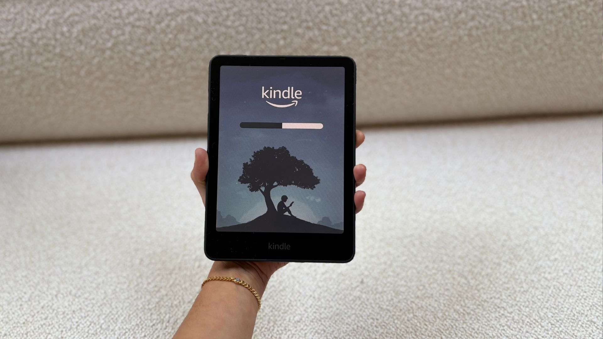 Kindle Colorsoft being held over the sofa
