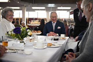 King Charles having afternoon tea with a group of seniors