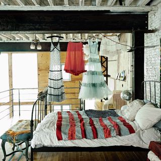bedroom with white bedlinen and hanging dresses