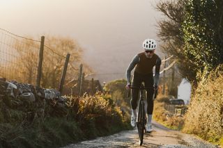 Image shows a rider cycling in the mountains