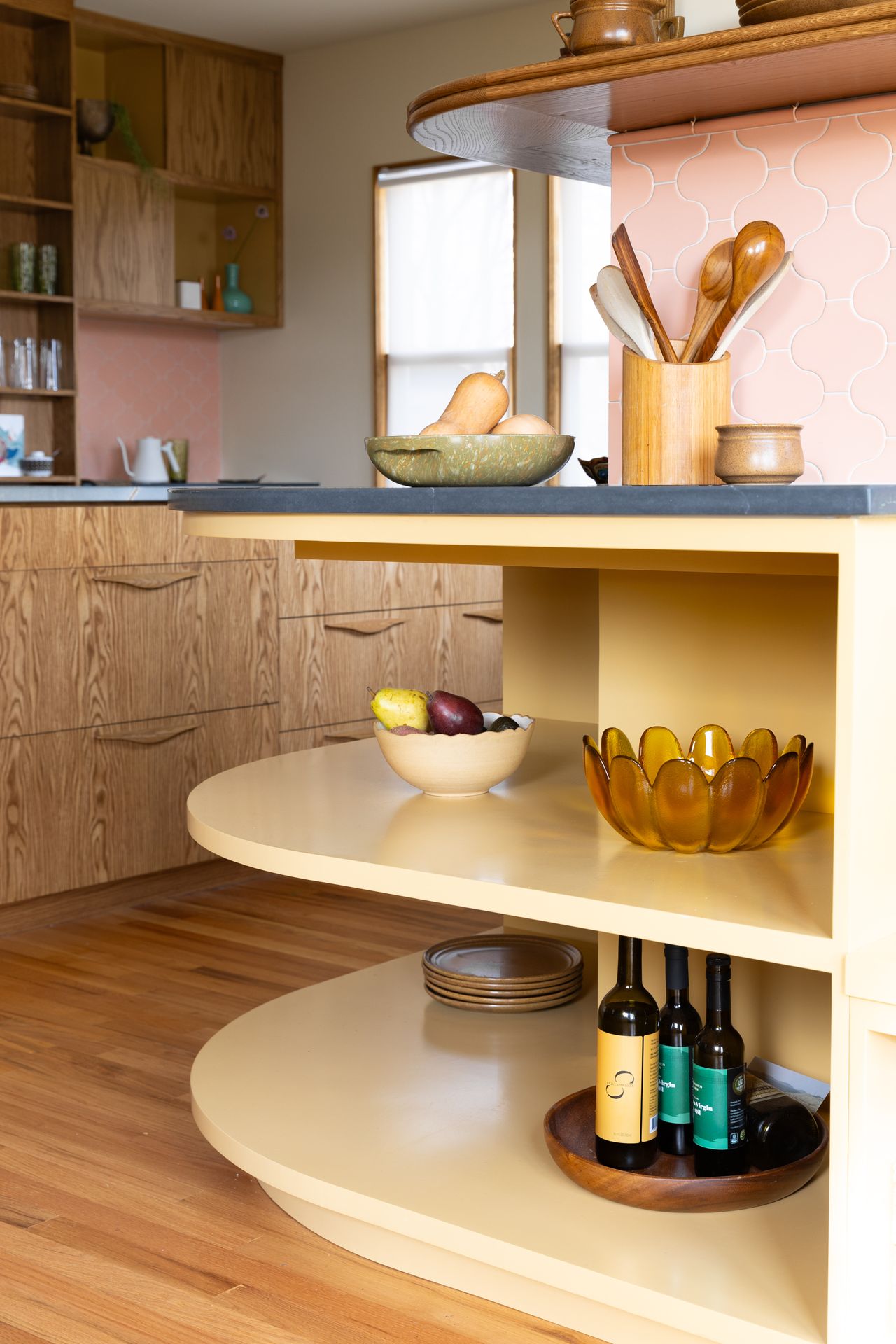 A kitchen with a yellow cabinet, in a rounded design