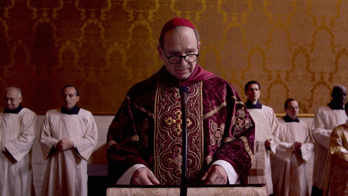 Ralph Fiennes in Conclave about to give a speech at a lecturn