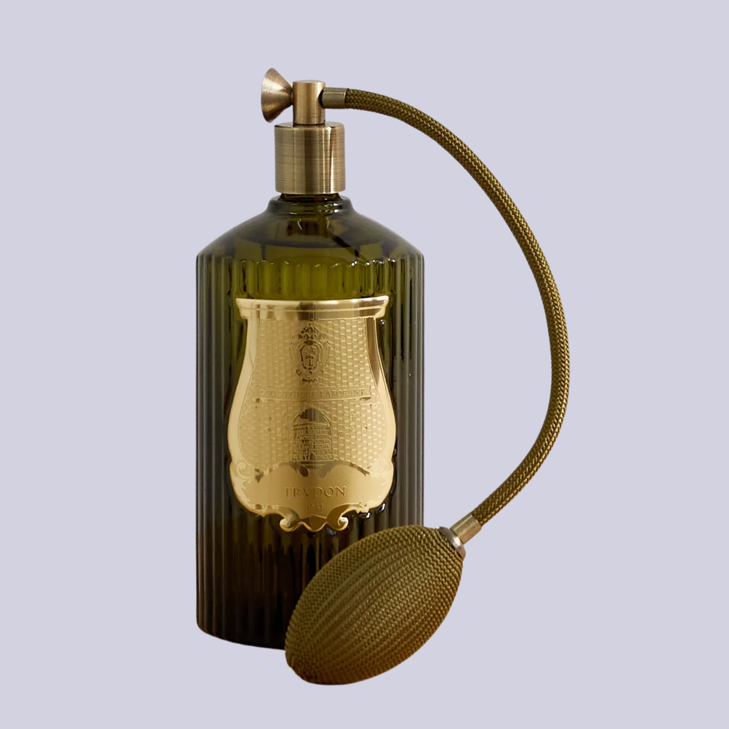A green vintage perfume bottle against a lilac backdrop