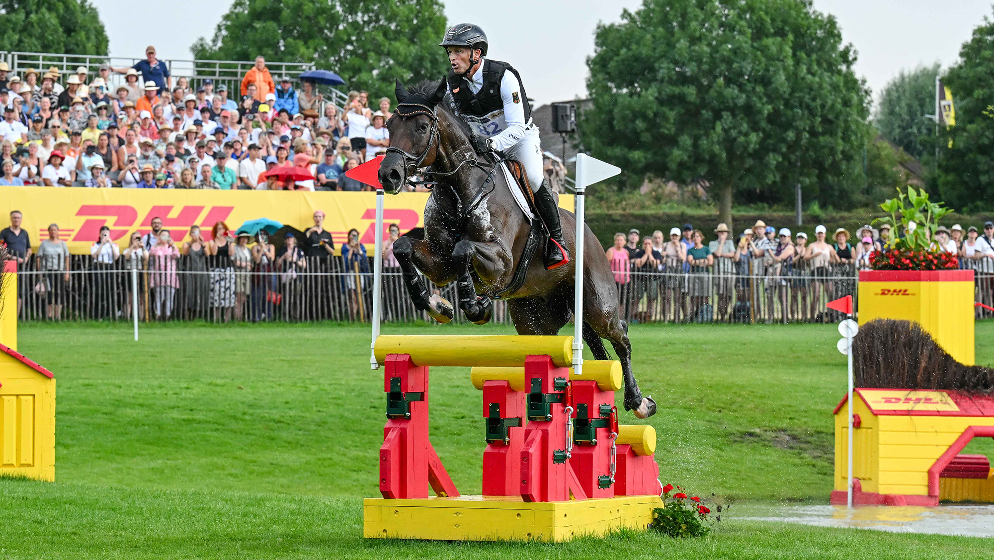 Michael Jung and Fischer Chipmunk clear a narrow triple bar cross-country fence painted red and yellow at Aachen eventing World Championships
