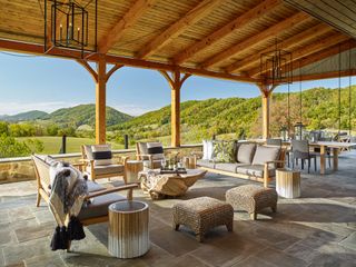 patio with wooden pergola and garden armchairs and table