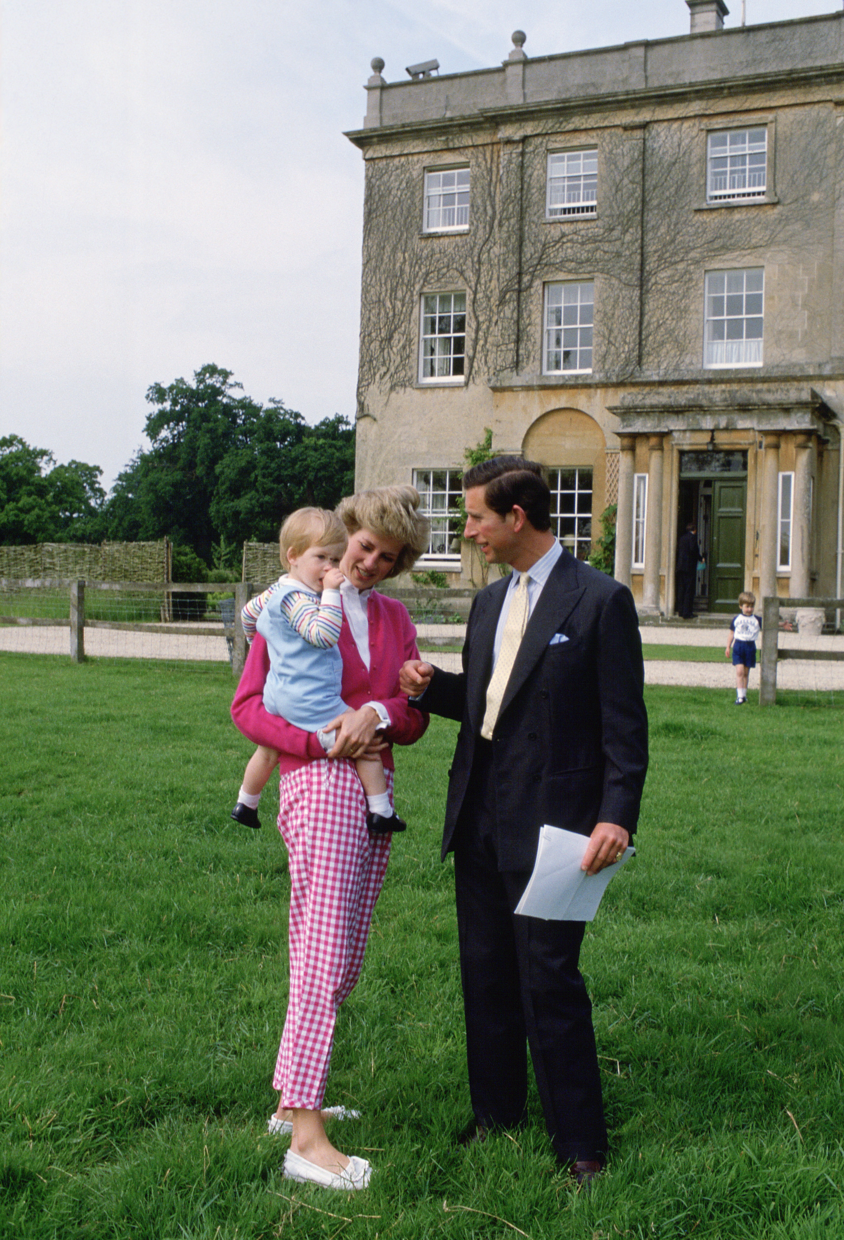 Prince Charles and Princess Diana standing outside Highgrove with Prince Harry