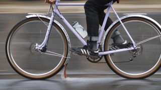 a pink bike with full metal fenders rides through the rain