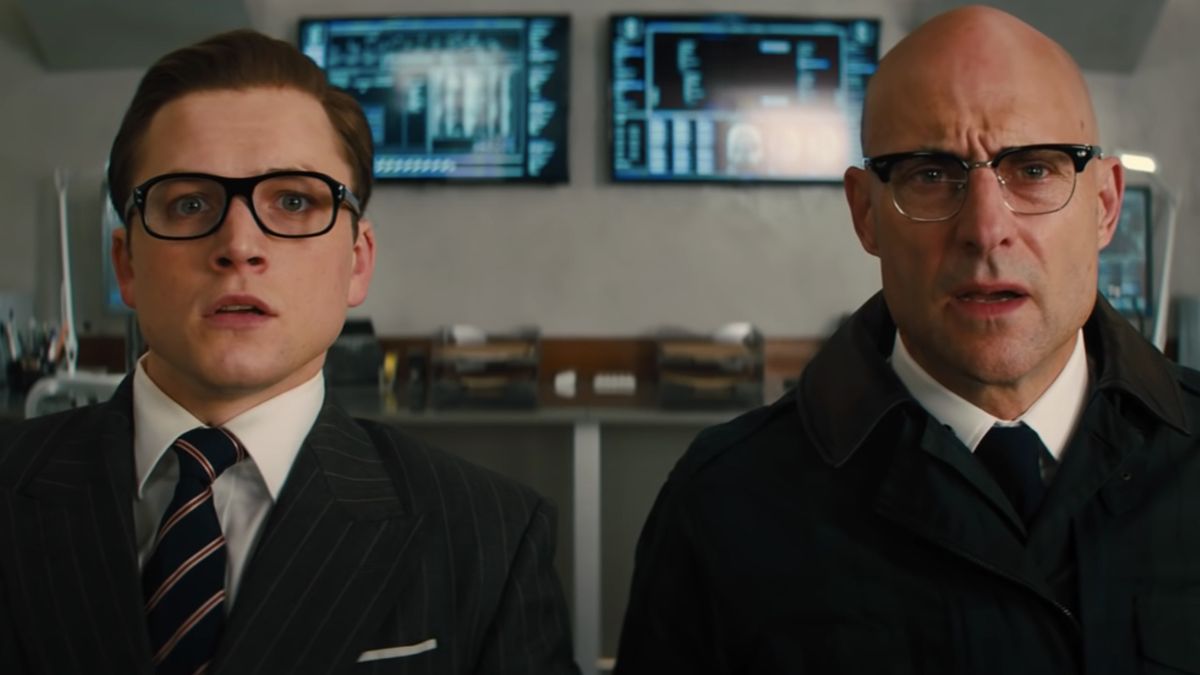 Taron Egerton and Mark Strong sit with stunned expressions in Kingsman: The Golden Circle.