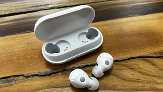 The Sony WF-C700N wireless earbuds in white, on a wooden background