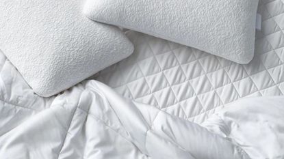 One of the best mattress protectors, the Sijo Clima, on a bed with pillows