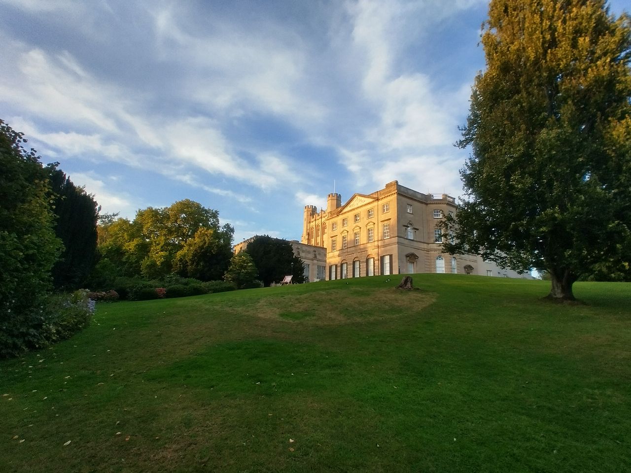 A photo of a mansion on a hill in ultra-wide